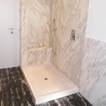 Piatto doccia in marmo con rivestimento in Calacatta oro a macchia aperta.